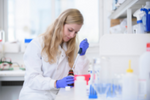 A Bristol researcher carrying out an experiment with large pipettes